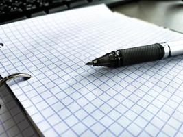 Selective focus of Pen, notebook on the wooden table and copy space with sunlight photo