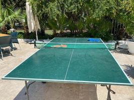 Ping pong rackets on game table with net, nobody photo