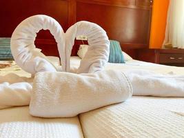descansar junto al mar en un hotel caro. al limpiar la habitación, el trabajador colocó cisnes de toallas en forma de corazón foto