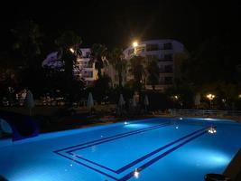 piscina y sombrillas de playa de césped con tumbonas por la noche, hora del amanecer foto