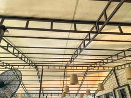 white false ceiling with black plastic slats. small, cream-colored chandeliers are attached to the ceiling, a fan for fresh air photo