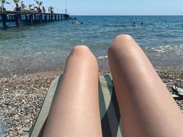 Low Section Of Woman Relaxing At Beach photo