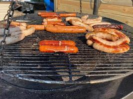 Delicious meat juicy ruddy fried on the grill and open fire on the grill barbecue sausages from chicken, pork, beef in a natural casing. Street food photo