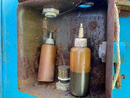 Old small jars are dirty with machine-made brown industrial oil. Oiler for lubrication of parts and internal combustion engine photo