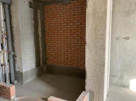 The apartment is in a new building without repair. Brick walls photo