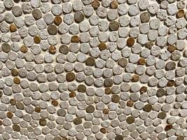 texture from stones. small, round stones are laid out in a row. white and brown stones create a natural, natural background photo