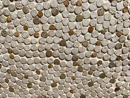 texture from stones. small, round stones are laid out in a row. white and brown stones create a natural, natural background photo