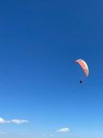 Skydiver flies under the canopy of a parachute, quickly approaching, close-up photo