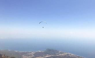 paragliding in the open sky, outdoor activities, travel in a warm country. bright parachute for a man. travel against the backdrop of high mountains photo