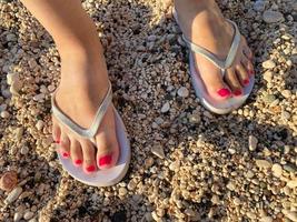 Selfie Shoes Isolated on Top View. Red Nails Manicure. Woman Wearing Gold Slippers Flip-Flop photo