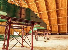 almacén de madera con materiales de construcción. muchas estructuras aptas para la construcción se almacenan en un almacén. dentro de la grúa de pórtico del almacén foto