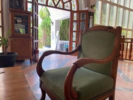 An old wooden antique armchair in the lobby of the hotel near the waiting table photo