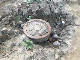 hatch for water sewers. hatch in the city, laying communications for the creation of a new microdistrict. hatch with concrete cover on top photo