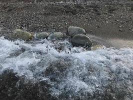 Large rocks are washed by clean, clear water of the Adriatic sea photo