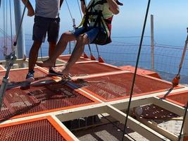 Concept of Extreme Sports and Fun. The instructor helps a man to jump with a rope photo