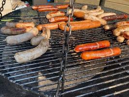 Grill czech sausages on on street food outdoor market. Fried baked sausages. European street food. Street food festival photo