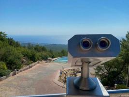 Touristic telescope look at the city with view of Barcelona Spain, close up old metal binoculars on background viewpoint overlooking the mountain, hipster coin operated in panorama observation, mockup photo