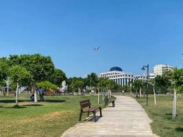 nuevo y hermoso parque moderno con plantas verdes, árboles tropicales y arbustos. lugar de descanso en la ciudad foto