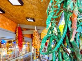 hot, red and green peppers are dried and hang on the counter. vegetables, vegan food, healthy food. pepper with green tail photo