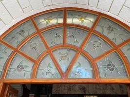 Image of a multicolored stained glass window with irregular block pattern in a hue of blue, square format photo