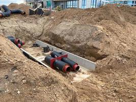 Large industrial modern new large diameter polyethylene plastic water pipes lie in a pit underground at a construction site during a water pipe repair photo