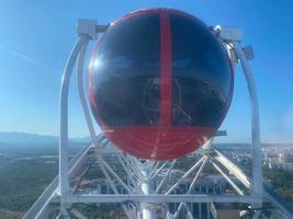 Ferris wheel cabins in a sunny day with white clouds photo