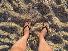 Low Section Of Man Standing On Shore At Beach photo