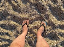 sección baja, de, hombre estar de pie, en la orilla, en, playa foto