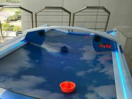 Air hockey table closeup with paddle at amusement arcade photo