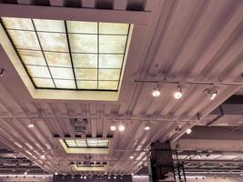 ceiling in a new building. metal sheet on the roof, black light bulbs attached to the ceiling. light sources on a stick. loft style apartment photo