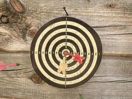 Dart board with color arrows hitting target, closeup photo