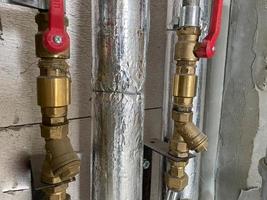 nuevas tuberías de agua y alcantarillado de plástico y polipropileno y plástico de polipropileno en aislamiento térmico con válvulas de cierre y cierre y control para el consumo de agua en una casa nueva sin reparación foto