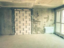 apartment in a new building. concrete blocks, house without repair with bare walls. battery in the room, walls made of gray blocks without finishing photo