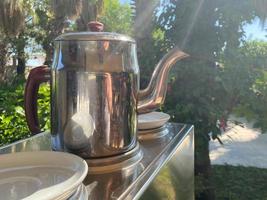 Tea table in the garden in summer time. Hygge style evening in the garden. photo