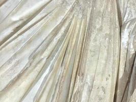 The texture of the stone shell yellow with the arrangement of layers on a diagonal. Natural decorative building material. Close-up, background of a golden warm hue photo