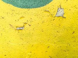 bulk paint on a piece of metal. bright texture. yellow and green circle. peeling paint, cracked material. paint and metal background photo