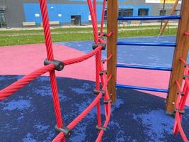 Children's new modern sports playground with various activities, games, swings, slides, carousels and sandpits with a rope town in the open-air courtyard photo