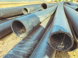 construction of a sewerage system in a new microdistrict. black rubber pipes lie on the sand at the construction site. drainage system photo