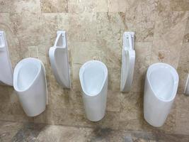 White urinals in men's bathroom, public toilet photo