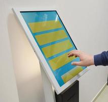 Man orders food in the touch screen terminal with electronic menu in fastfood restaurant. Modern technology concept photo