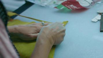 máquina de coser en un taller de cuero en acción con manos trabajando en detalles de cuero para zapatos. tiro macro de las manos de las mujeres con la máquina de coser en la fábrica de zapatos video