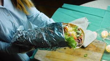 Very large burrito with avocado and chorizo meat. Filming in a romantic setting. Macro shooting