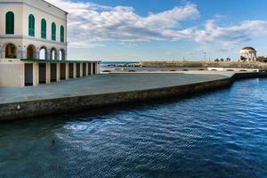 livorno,italia-27 de noviembre de 2022-caminar por el paseo marítimo de livorno durante un día soleado y con terraza mascagni en el backgraund foto