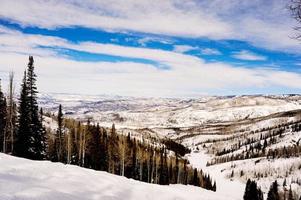 A wintry mountain landscape with snow and mountains as far as the eye can see. photo