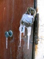 Close up of old rusty lock frozen with icicles photo