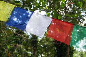 View on a colorful flags on a background of trees on a sunny day. Chiang Mai province, Doi Suthep, Thailand. photo