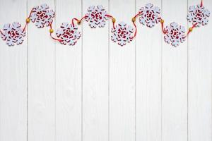 Christmas background with red felt snowflakes garland. Top view, flat lay with copy space photo