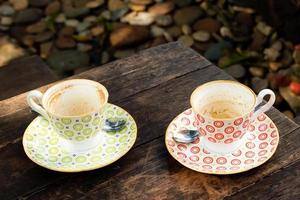 Two empty colorful cups after drinking coffee on a wooden table in a cafe. photo