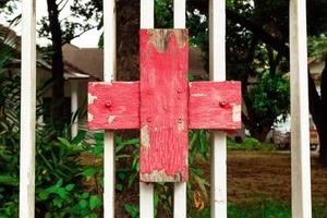 Red and white wooden cross near to clinic. Medical symbol. photo