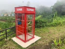 A classic British red telephone booth tucked away in the mountains photo